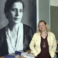 Gerlinde Fritz vor einem Portrait von Lise Meitner